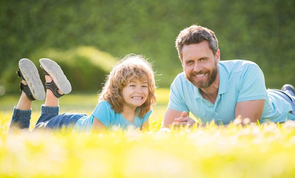 szczęśliwa rodzina ojca i syna zrelaksować się w parku letnim zielona trawa, ojcostwo - Zdjęcie, obraz