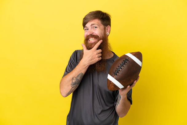 Redhead caucasian man playing rugby isolated on yellow background  - Photo, Image