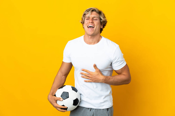 Άγγλος ποδοσφαιριστής πάνω από απομονωμένο κίτρινο φόντο χαμογελώντας πολύ - Φωτογραφία, εικόνα