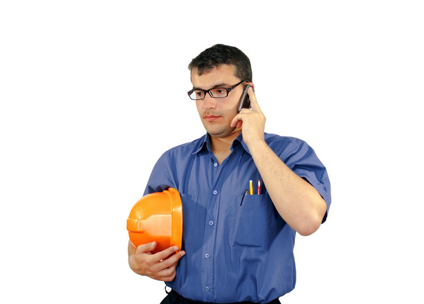 καυκάσιος νεαρός με κατασκευή κράνος μιλά στο τηλέφωνο - Φωτογραφία, εικόνα