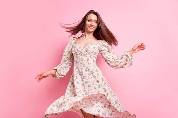 Photo portrait smiling girl dancing in printed dress at party isolated pastel pink color background - Φωτογραφία, εικόνα