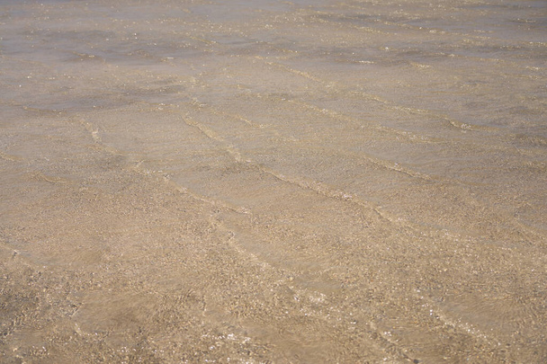 Powierzchnia czystej wody na tropikalnej, piaszczystej plaży na Krecie Grecja - Zdjęcie, obraz