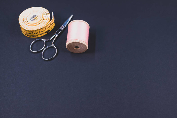 A closeup shot of sewing accessories on a black background - Valokuva, kuva