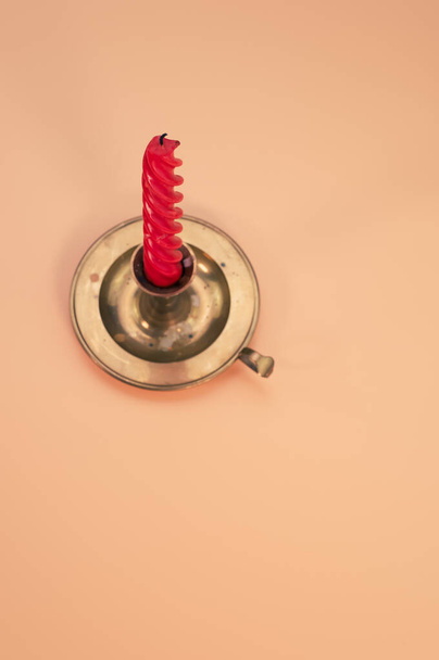 A vertica shot of a candle on a coral background - Fotografie, Obrázek