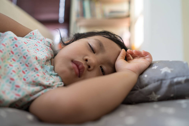 A cute Asian little girl sleeping in her bed - Фото, зображення