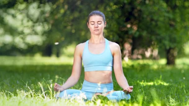 Lady athlete meditates sitting in yoga pose after exercises - Footage, Video