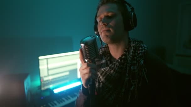 Hombre guapo grabando una canción en un estudio de grabación. - Metraje, vídeo