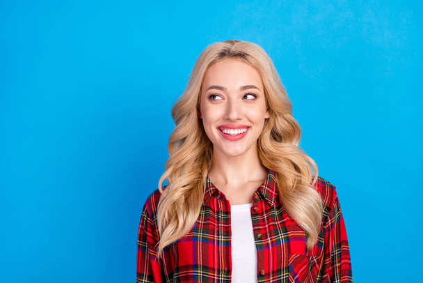 Photo of optimistic blond hairdo young lady look empty space wear red shirt isolated on blue color background - Fotografie, Obrázek