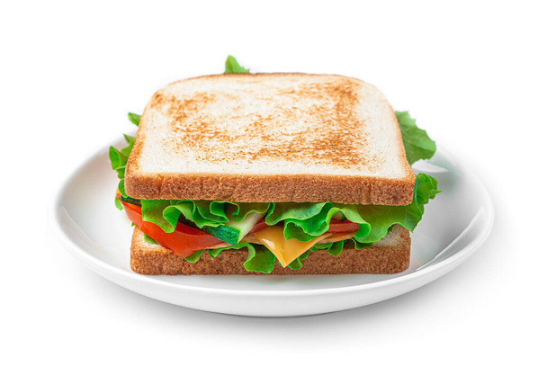 Panino con prosciutto, formaggio, verdure e insalata in un piatto su fondo bianco. - Foto, immagini