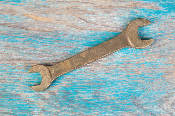 Vintage Bronze Schraubenschlüssel auf schäbigem blauem Holzhintergrund. Kopierraum für Text. - Foto, Bild
