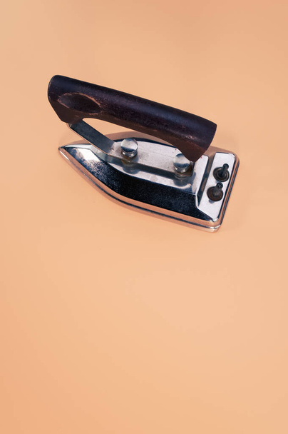 A clothes iron isolated on a beige background with free space for text - Photo, image