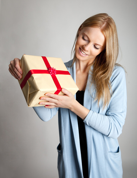 Happy beautiful young woman holding gift box - 写真・画像