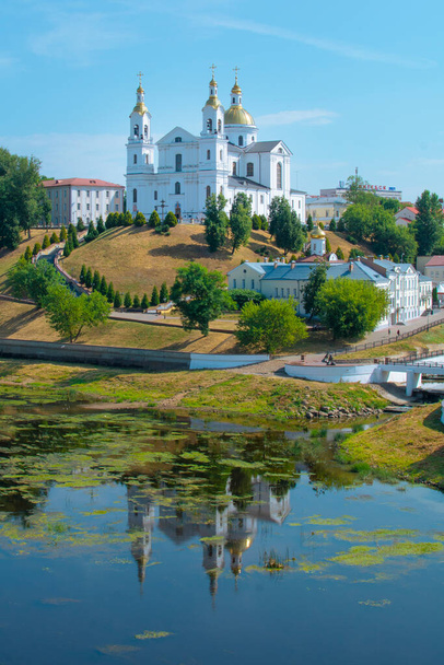 Vitebsk, Wit-Rusland - 16 juli 2021: Heilige Hemelvaart Kathedraal van de Hemelvaart op de heuvel en de Heilige Geest klooster en de Westelijke Dvina Rivier. Vitebsk, Belarus - Foto, afbeelding