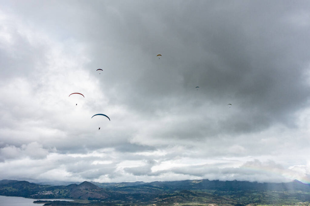 Gleitschirmflug über den Berg mit Wolken im Hintergrund - Foto, Bild
