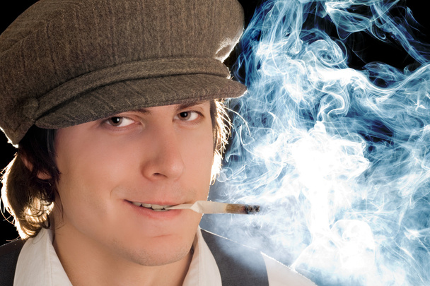 ちゃめっ気たっぷりの笑顔での喫煙男性の肖像画。黒に分離 - 写真・画像