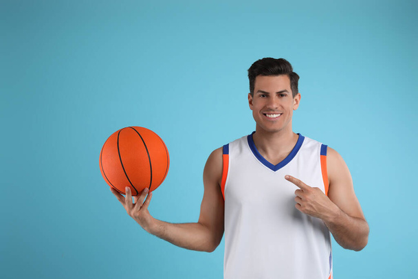 Basketball player with ball on light blue background - Photo, image