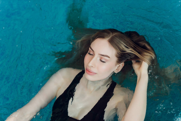 Beautiful young blond woman at swimming pool. - Zdjęcie, obraz