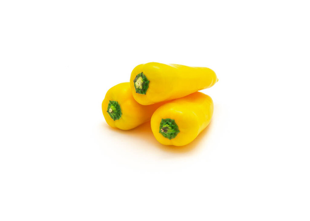 Tre vivaci mini peperoni gialli si isolano su sfondo bianco. Minuscoli mini snack peperoni sono più dolci della media peperone. - Foto, immagini