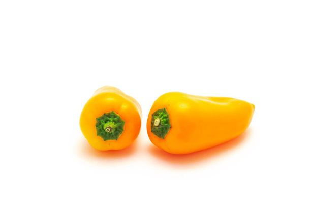 Kaksi elinvoimainen oranssi mini paprikat eristää valkoisella pohjalla. Pienet minipaprikat ovat keskimääräistä makeampia. - Valokuva, kuva