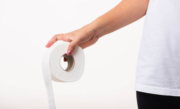 Closeup Asian young woman diarrhea constipation holding stomachache and tissue toilet paper roll on hand she crotch lower abdomen want to WC, studio shot isolated on white background, Health care - Foto, imagen