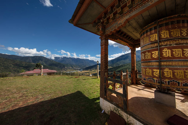 Egy buddhista imadobot Buthan hegyeiben. A szimbólumok fordítása a dobon a jólét, a szentség és a buddhizmus mantrája vagy a buddhizmus tanításai. - Fotó, kép