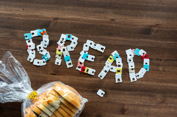 Top dow view of the word bread made from bread bag packaging clips. - Photo, Image