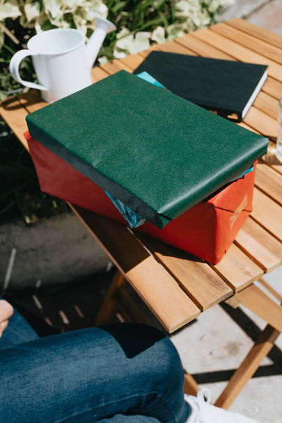 Les cadeaux joliment emballés sur une table en bois à l'extérieur par une journée ensoleillée - Photo, image