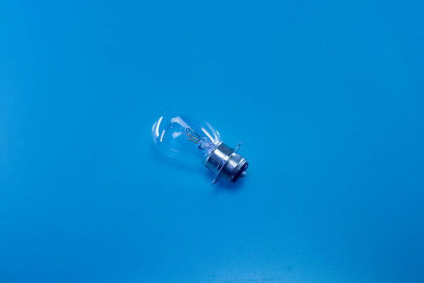The light bulb of an automotive vehicle on a blue background - Foto, Imagen
