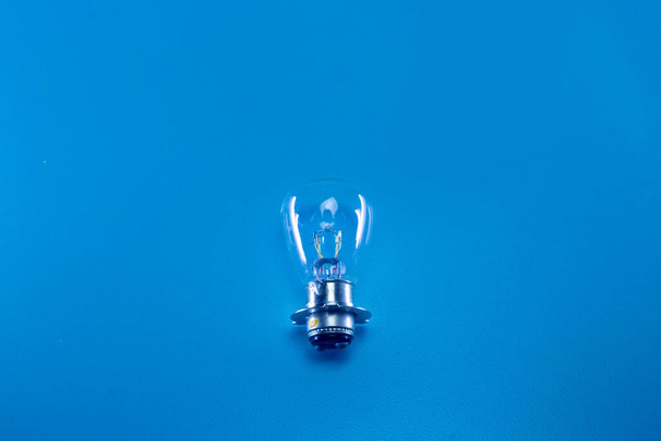 The light bulb of an automotive vehicle on a blue background - Photo, Image