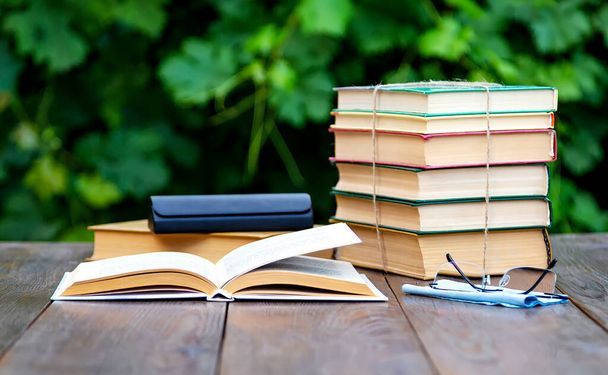 Books and reading glasses on the garden table. - Foto, Imagem