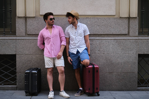 Homosexuelle Paare von Touristen stehen gegen die Wand und schauen einander an. - Foto, Bild