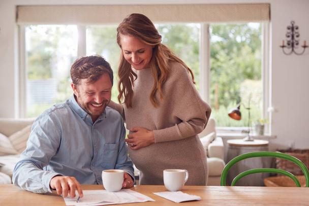 Couple With Pregnant Wife Reviewing Domestic Finances Together - Foto, Imagen