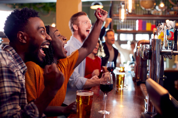 Group Of Excited Customers In Sports Bar Watching Sporting Event On Television - Fotó, kép