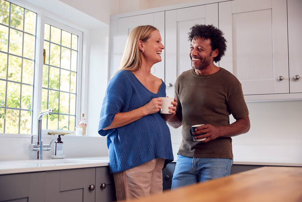 Couple With Pregnant Wife In Kitchen Talking And Drinking Coffee Together - Foto, immagini