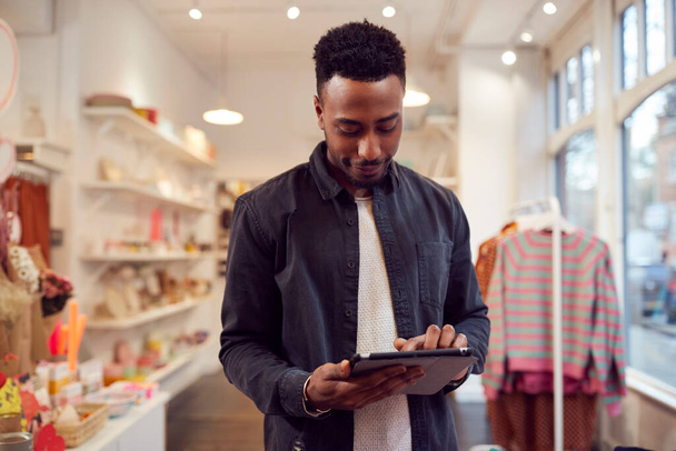 Male Small Business Owner Checks Stock In Shop Using Digital Tablet - Foto, Imagem
