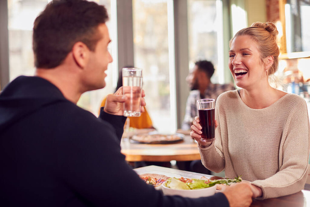 Smiling Couple On Date Enjoying Pizza In Restaurant Together - Fotó, kép