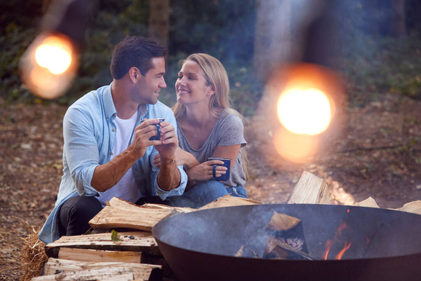 Romantic Couple Camping Sitting By Bonfire In Fire Bowl With Hot Drinks - Fotografie, Obrázek
