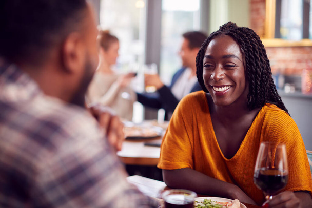 Smiling Young Couple On Date Enjoying Pizza In Restaurant Together - Photo, Image