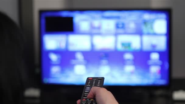 Smart TV y la mano joven mujer presionando el control remoto
 - Metraje, vídeo