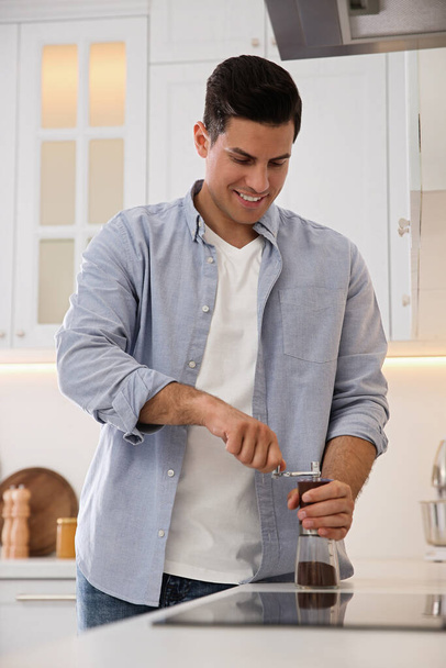 Man using manual coffee grinder in kitchen - Foto, Imagem
