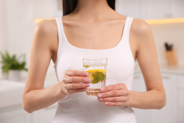 Young woman with glass of fresh lemonade at home, closeup - 写真・画像