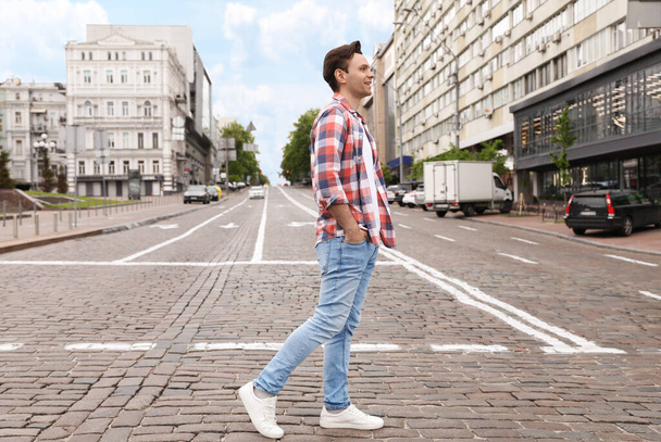 Young man crossing street. Traffic rules and regulations - Фото, изображение