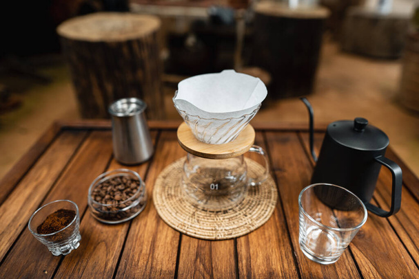 Verter agua caliente en el café., Gotear el café en una mesa de madera en casa - Foto, imagen