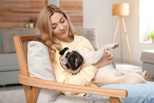 Woman with cute pug dog at home. Animal adoption - 写真・画像