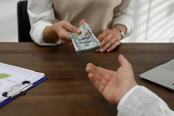 Cashier giving money to businessman at desk in bank, closeup - Φωτογραφία, εικόνα