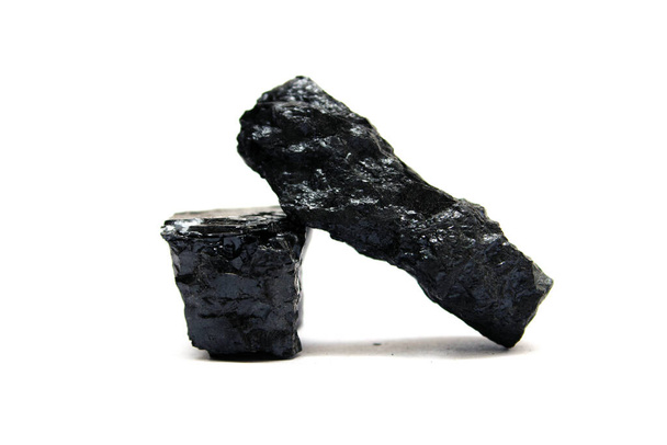 Zwei Stücke Anthrazitkohle auf Weiß. Kohle ist einer der am weitesten verbreiteten fossilen Brennstoffe und ein wichtiger Bestandteil der Stromerzeugung in der Welt. - Foto, Bild