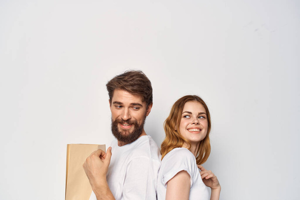 young couple standing next to family shopping light background - Photo, Image