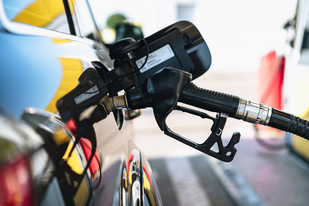 Pumping gasoline fuel in brown car at gas station - Fotó, kép