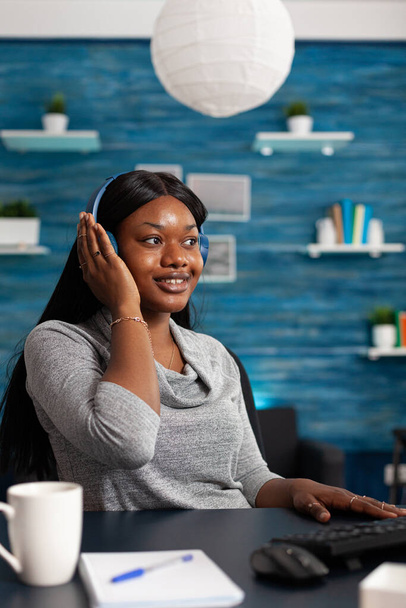 African american student wearing headphone listening online learning course - Foto, immagini