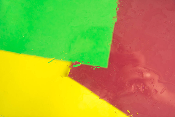 Fundo multicolorido de verde, amarelo e vermelho com estirpes e gotas de água. Abstrato brilhante e colorido pano de fundo. - Foto, Imagem